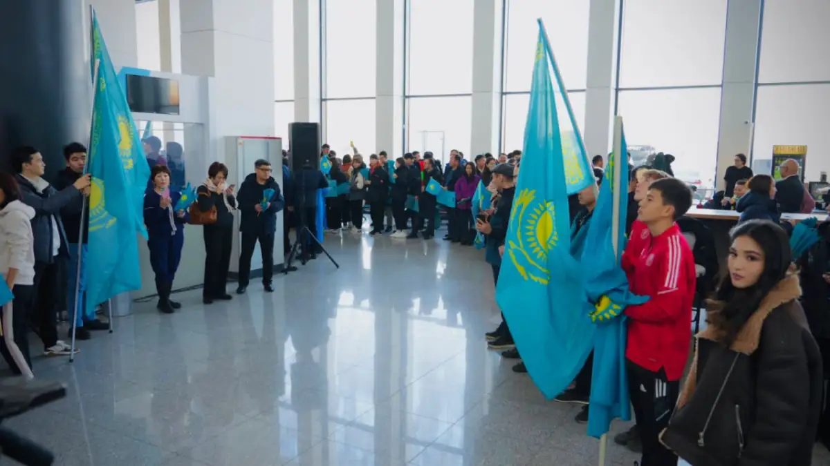 Футболистов сборной Казахстана встретили в Астане баннерами и с флагами