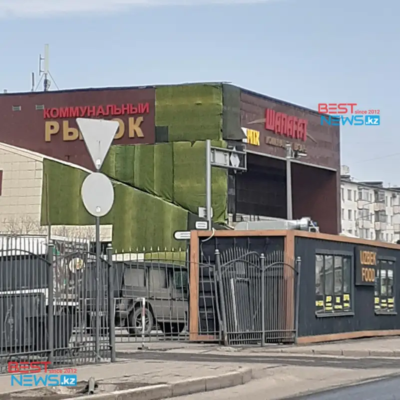 Обгоревший фасад рынка "Шапагат" замаскировали тканью - фото