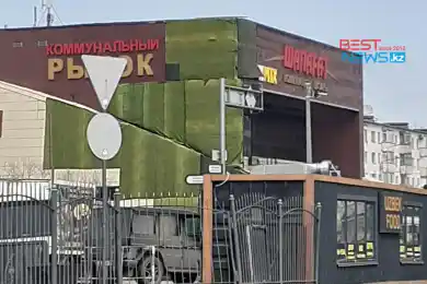 Обгоревший фасад рынка "Шапагат" замаскировали тканью - фото